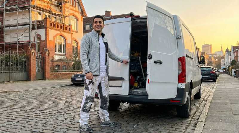 Stuckateurmeister Aras Kaplan an seinem Transporter bei Sonnenuntergang