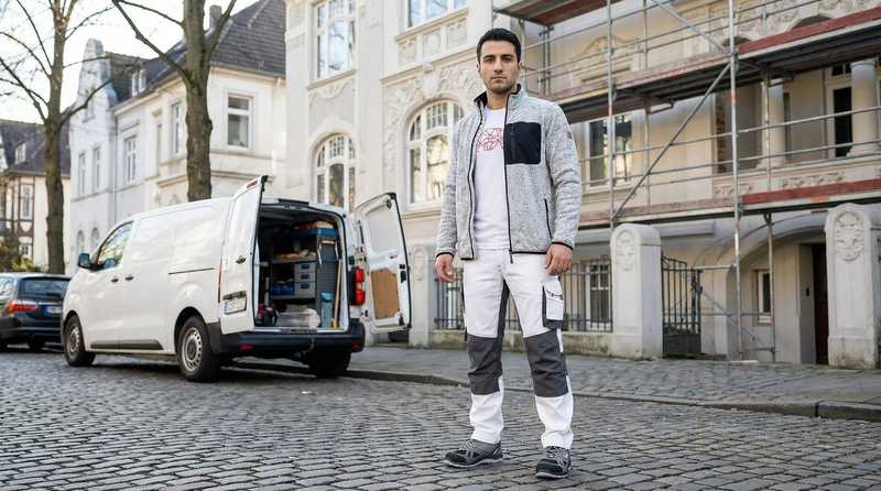 Stuckateurmeister Aras Kaplan vor seinem Transporter - bereit fuer den Einsatz