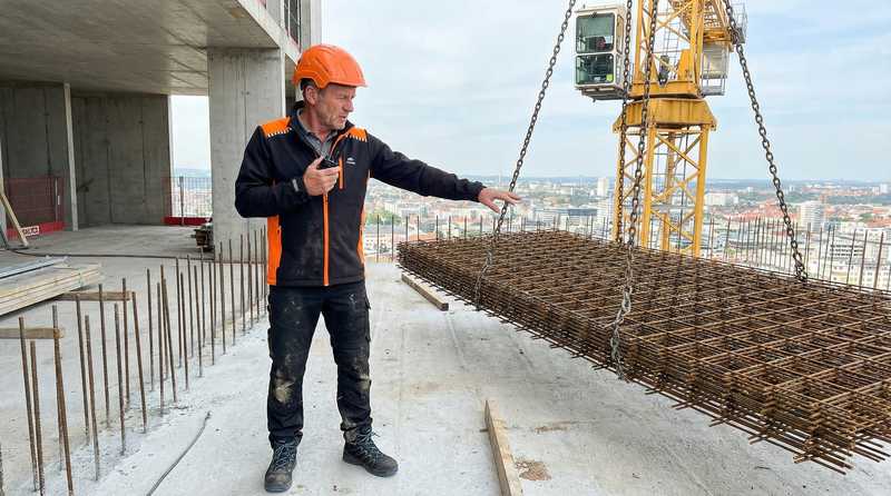 Polier Hans Frick auf der Hochbaustelle - professionelle Arbeitskleidung und Sicherheitsausruestung fuer den Rohbau
