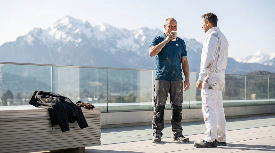 Fliesenleger Richard Gruber und ein Kollege in Workwear bei der Kaffeepause - gemeinsam die Baustelle besprechen und planen