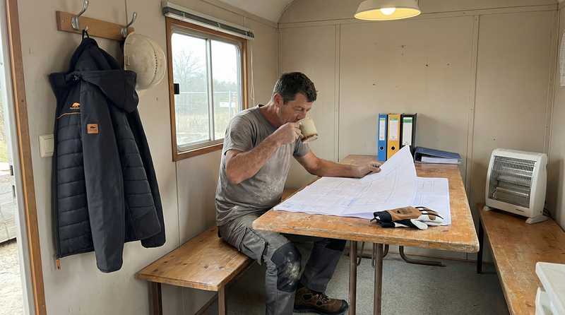 Maurer Matteo Rossi bei der verdienten Kaffeepause auf der Baustelle - Arbeitsalltag im Hochbau