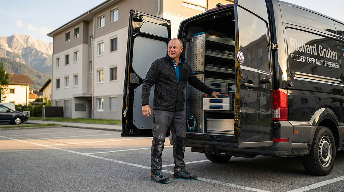 Fliesenleger Richard Gruber laedt grosse Fliesenplatten in professioneller Workwear aus dem Firmenfahrzeug - Vorbereitung ist alles